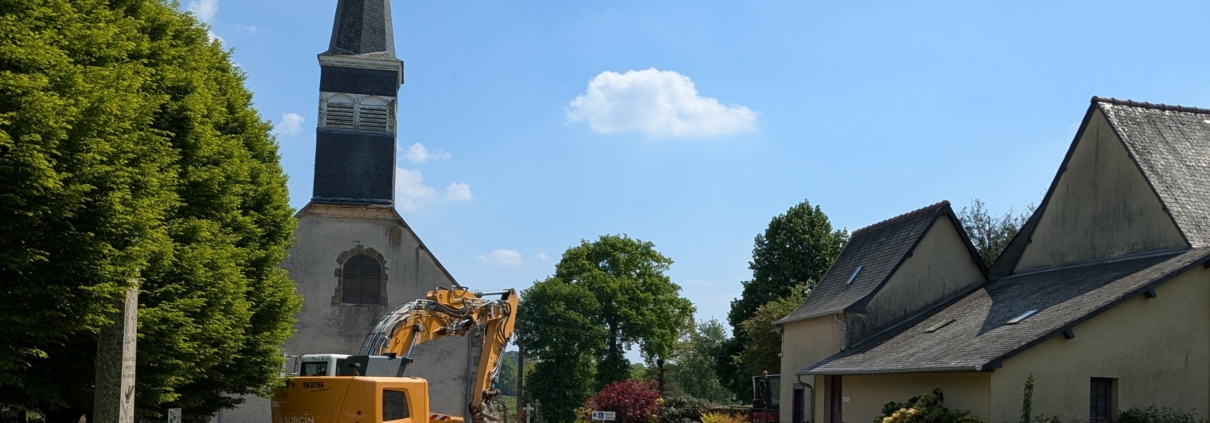 Photographie montrant une pelleteuse en action devant l'église paroissiale de Saint-Sulpice-la-Forêt