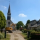 Photographie montrant une pelleteuse en action devant l'église paroissiale de Saint-Sulpice-la-Forêt